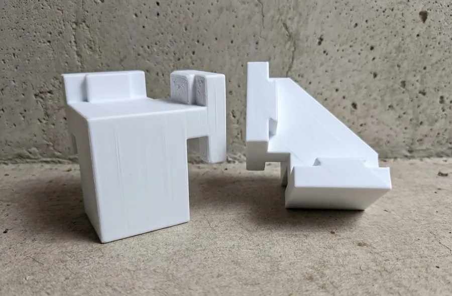 Two white 3D printed Corner blocks showing the H-shape key and interlock channel